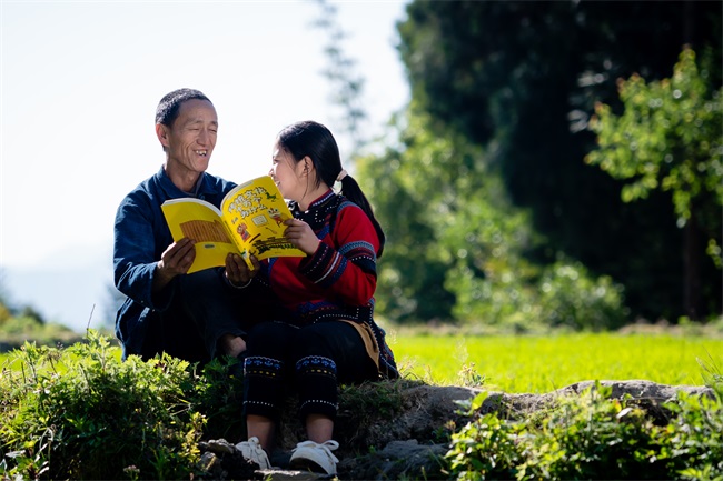 2许三机与孙女一起在田间看书。.jpg