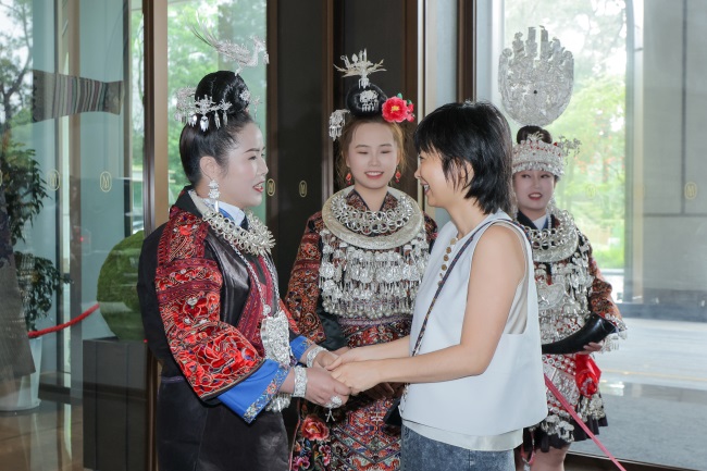 1784606027725028790.jpg 4.设计师赵卉洲与来自贵州的绣娘在展览现场亲切互动.jpg